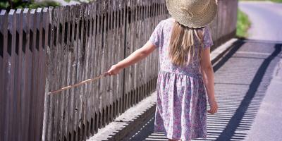Image of a child walking down a fence
