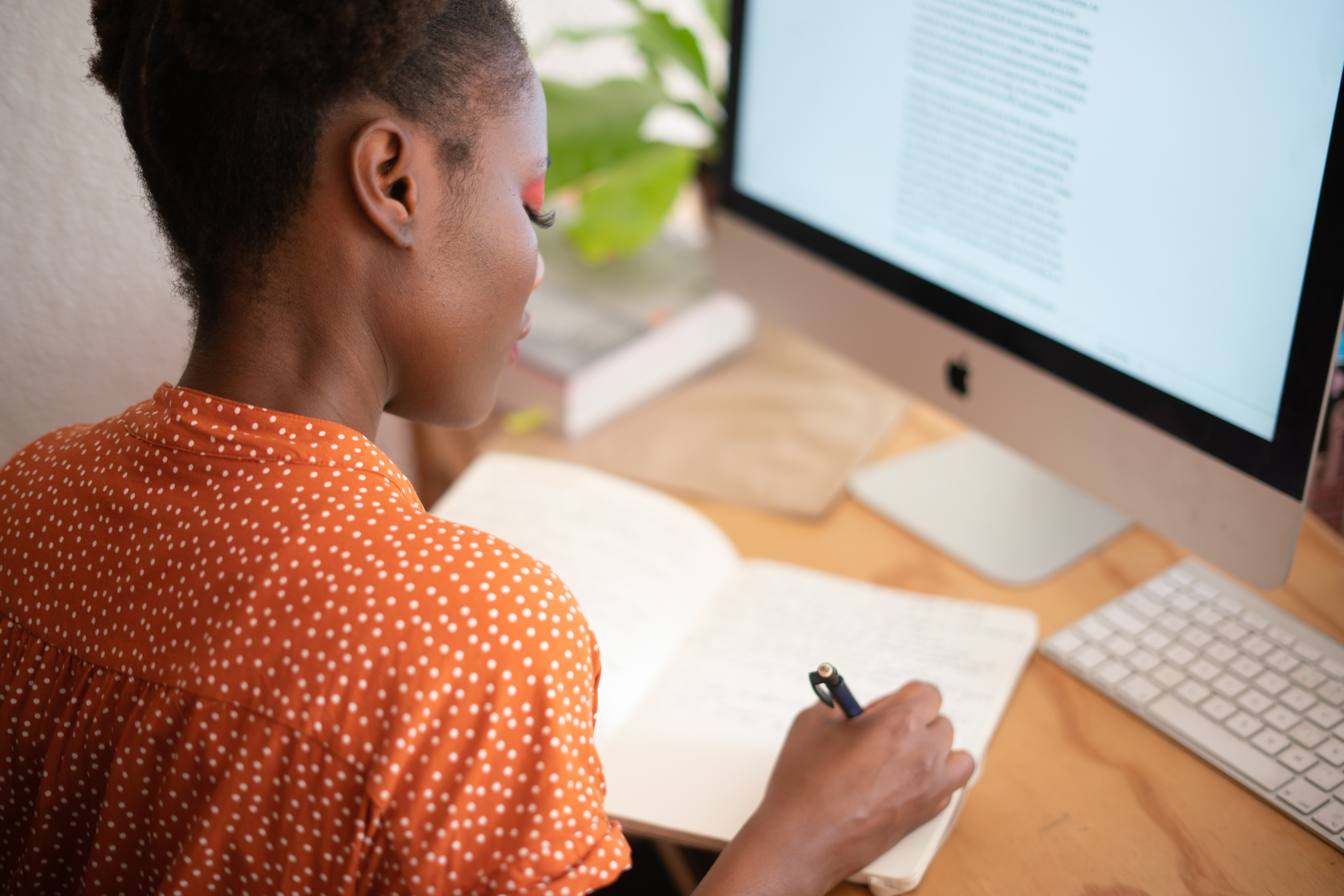 black woman writing laptop 