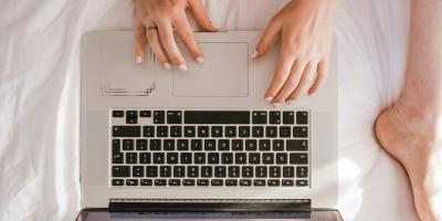 woman and laptop on bed