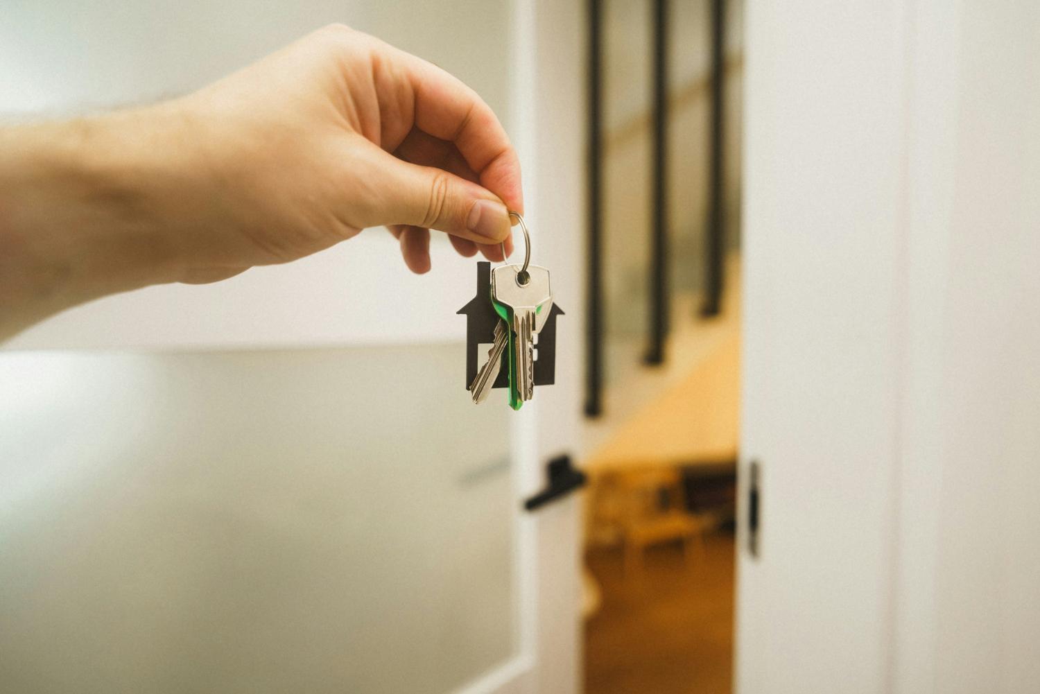 a hand holding a key to a door 