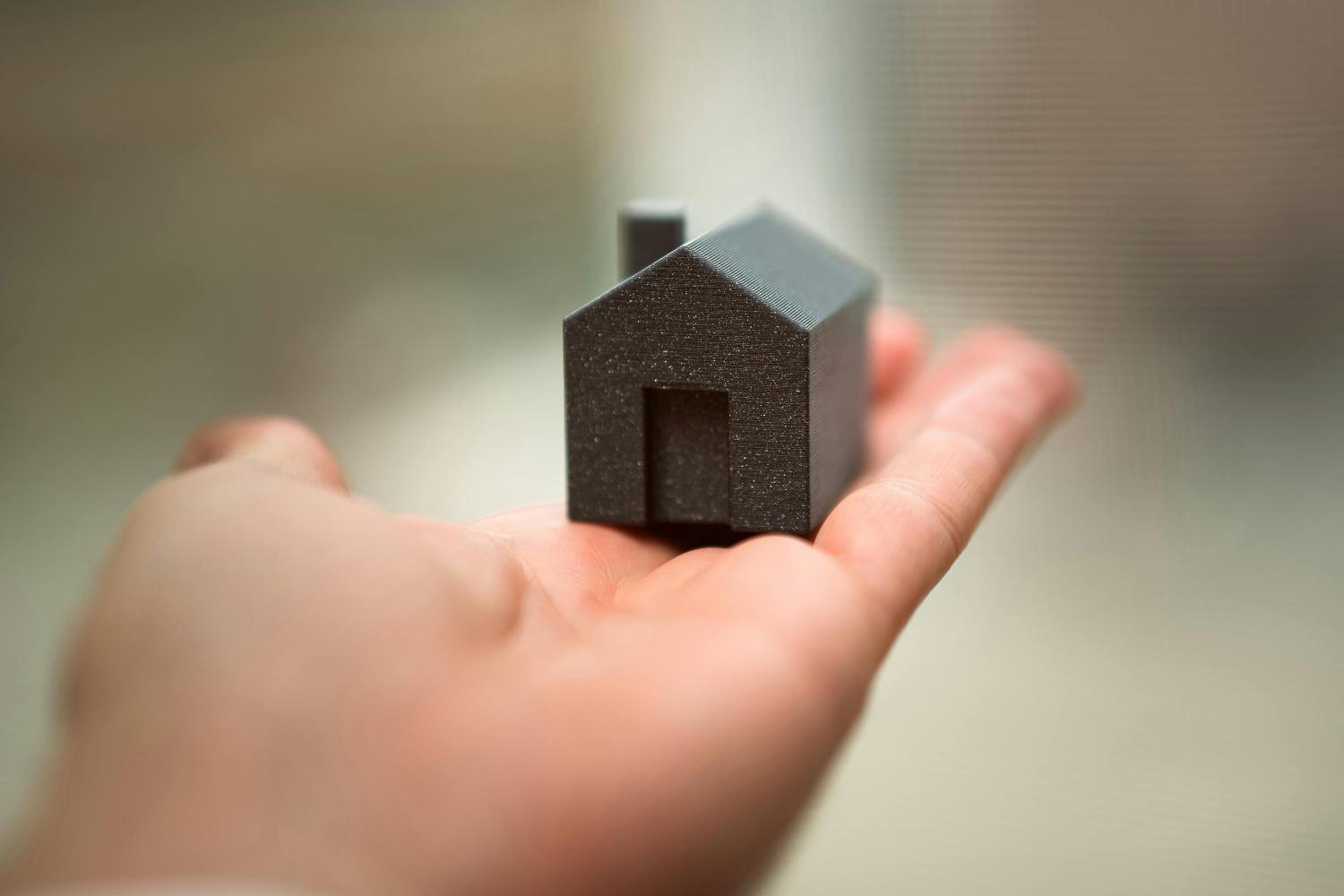 hand holding small model house 