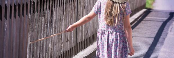 Image of a child walking down a fence