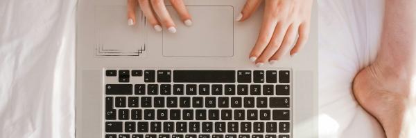 woman and laptop on bed